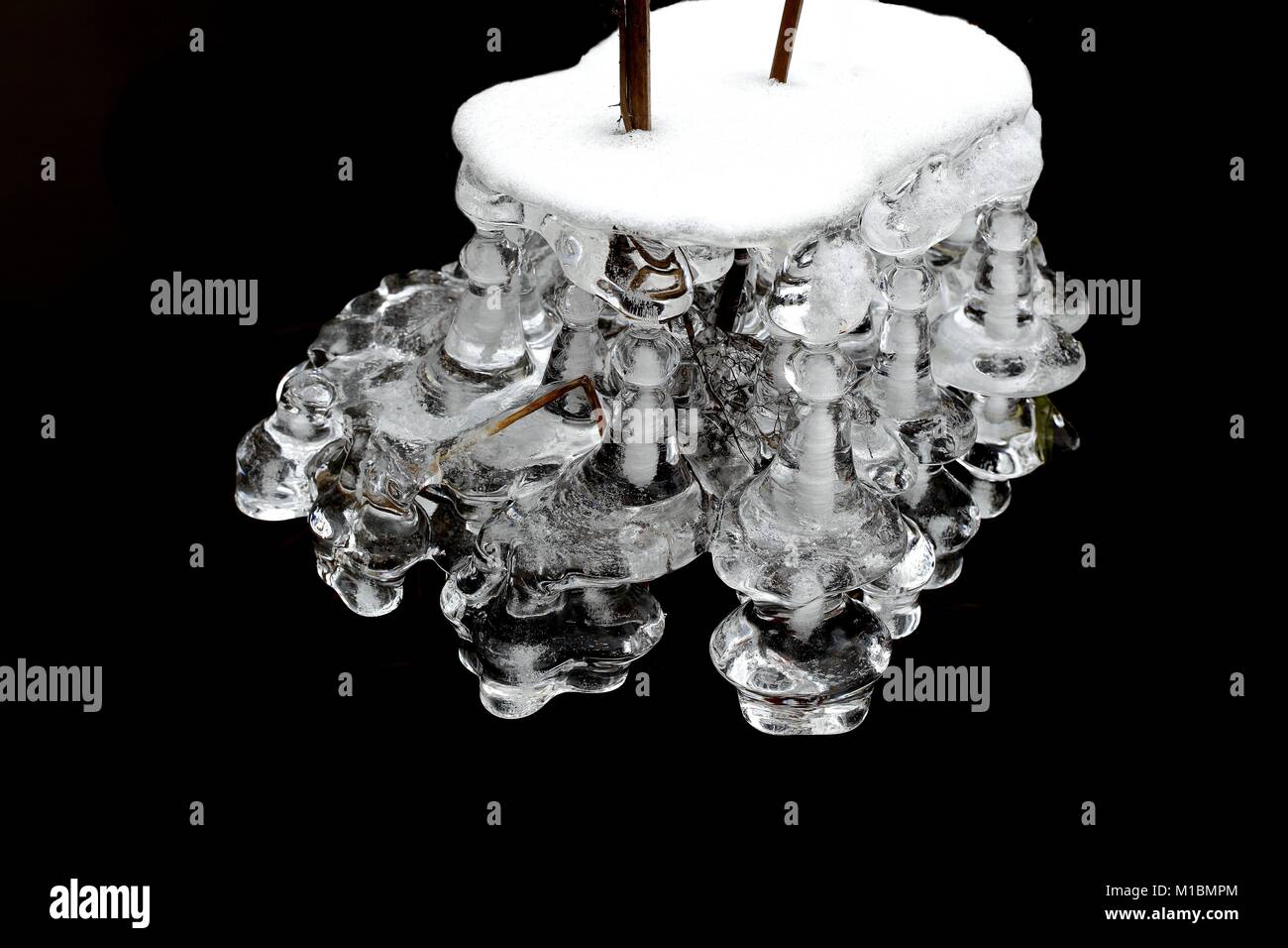 Eiszapfen durch Wasser in einem Bach in Finnland geprägt Stockfoto