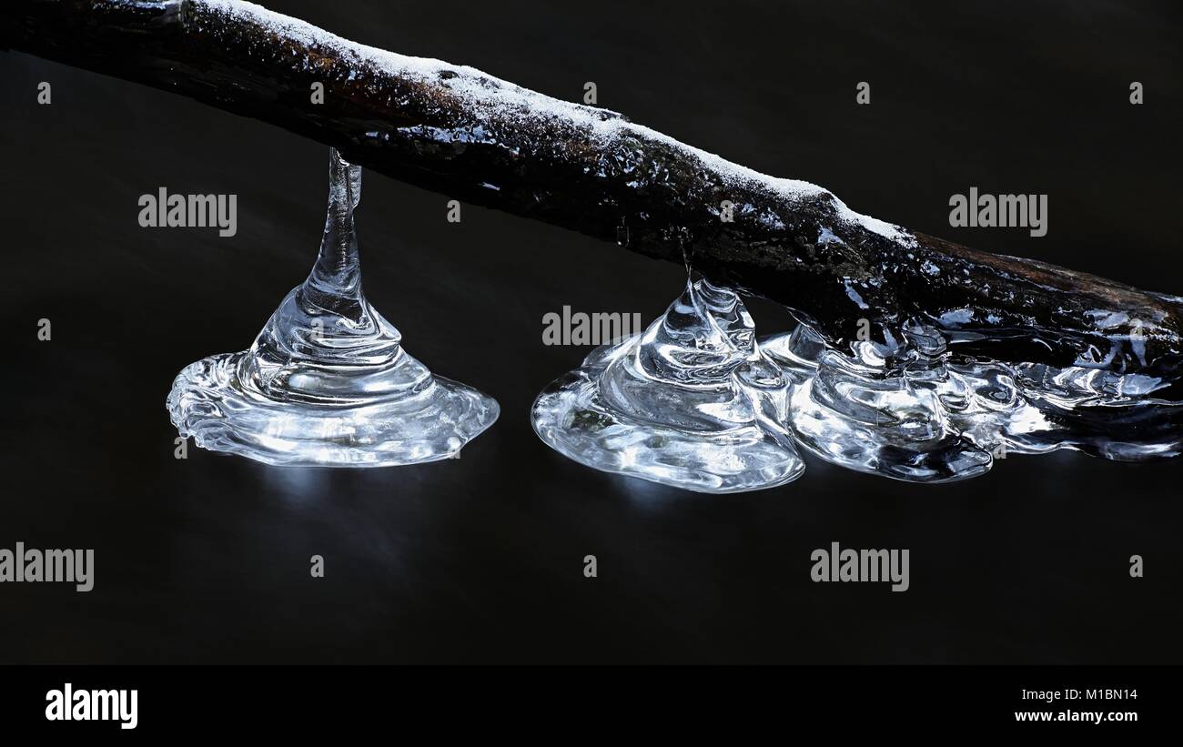 Eiszapfen durch Wasser in einem Bach in Finnland geprägt Stockfoto