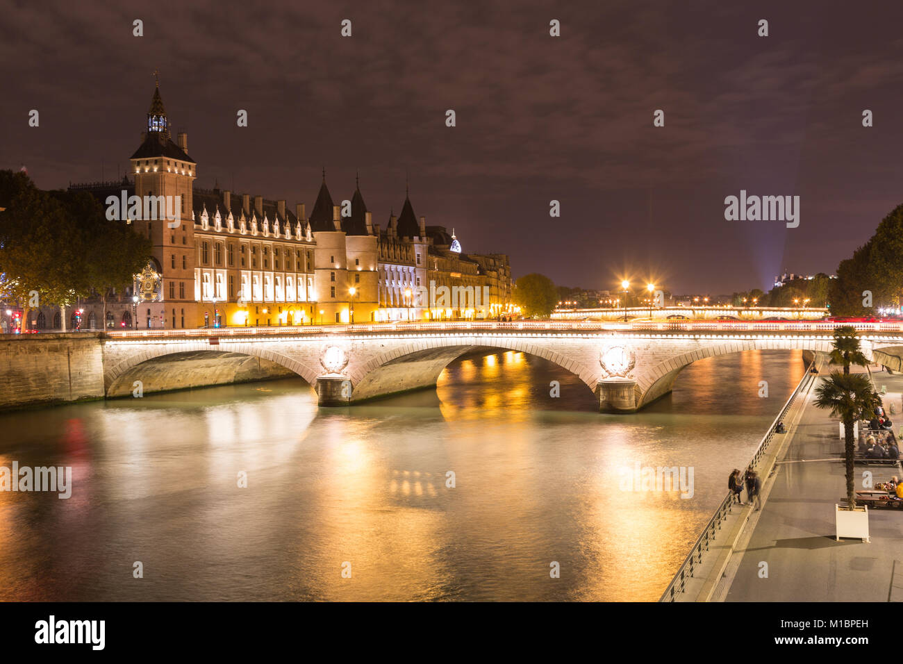 Conciergerie und Pont au Change an den Ufern der Seine in der Nacht, Île de la Cité, Paris, Frankreich Stockfoto