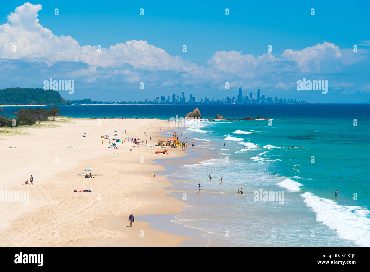 Currumbin, Queensland, Australia-December 23, 2017: Coastal sand Strand mit Gold Coast Skyline von Surfers Paradise am Horizont, eine wichtige touristische Stockfoto