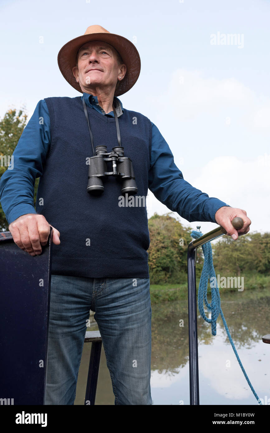 Kapitän eines 15-04 trägt einen Strohhut auf einem englischen Wasserstraße Lenkung das Boot mit der Lenkstange. Stockfoto