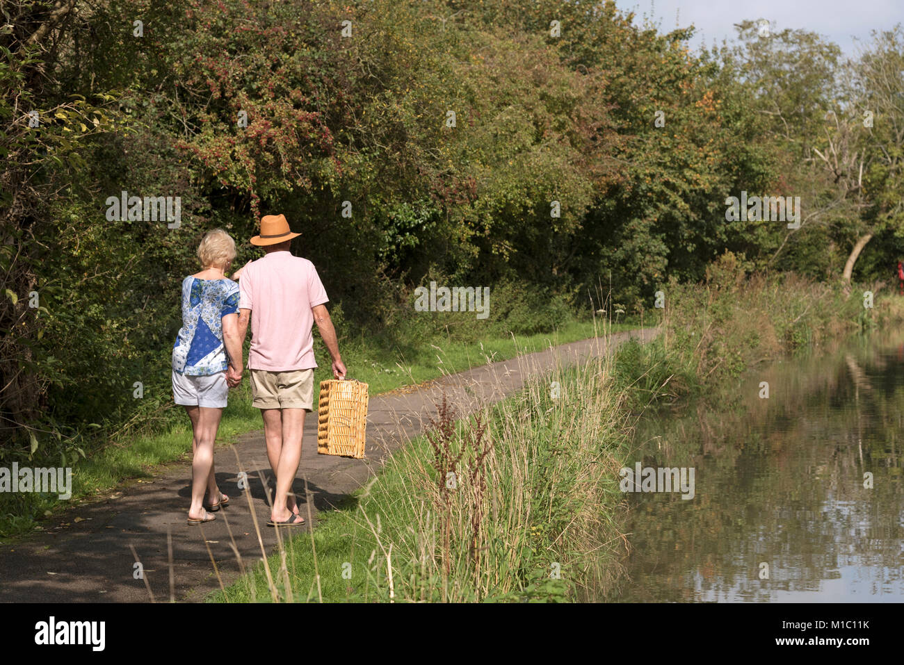 Paar mit einem Picknickkorb auf einem leinpfad am Fluss Stockfoto