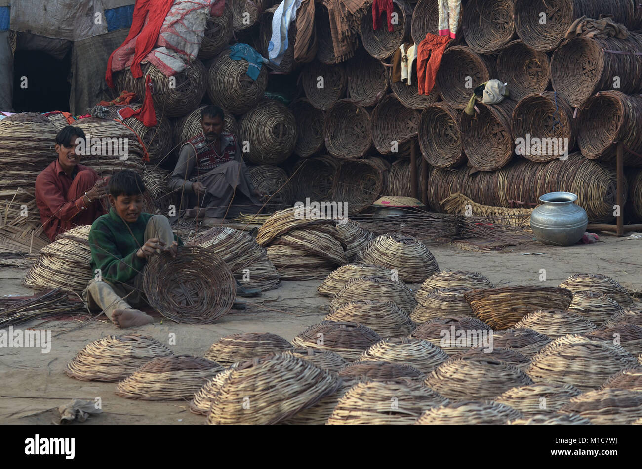 Lahore, Pakistan. 29 Jan, 2018. Pakistanische Gipsy Familie arbeitet momentan an Der traditionelle Korb aus trockenen Zweigen. Das Flechten von Körben ist so alt wie die Geschichte des Menschen. Spuren von Körbe haben in den Ägyptischen Pyramiden gefunden worden, und geflochtenen Korb Büchsen haben ihre Eindrücke in die Fragmente der antiken Keramik links. Credit: Rana Sajid Hussain/Pacific Press/Alamy leben Nachrichten Stockfoto