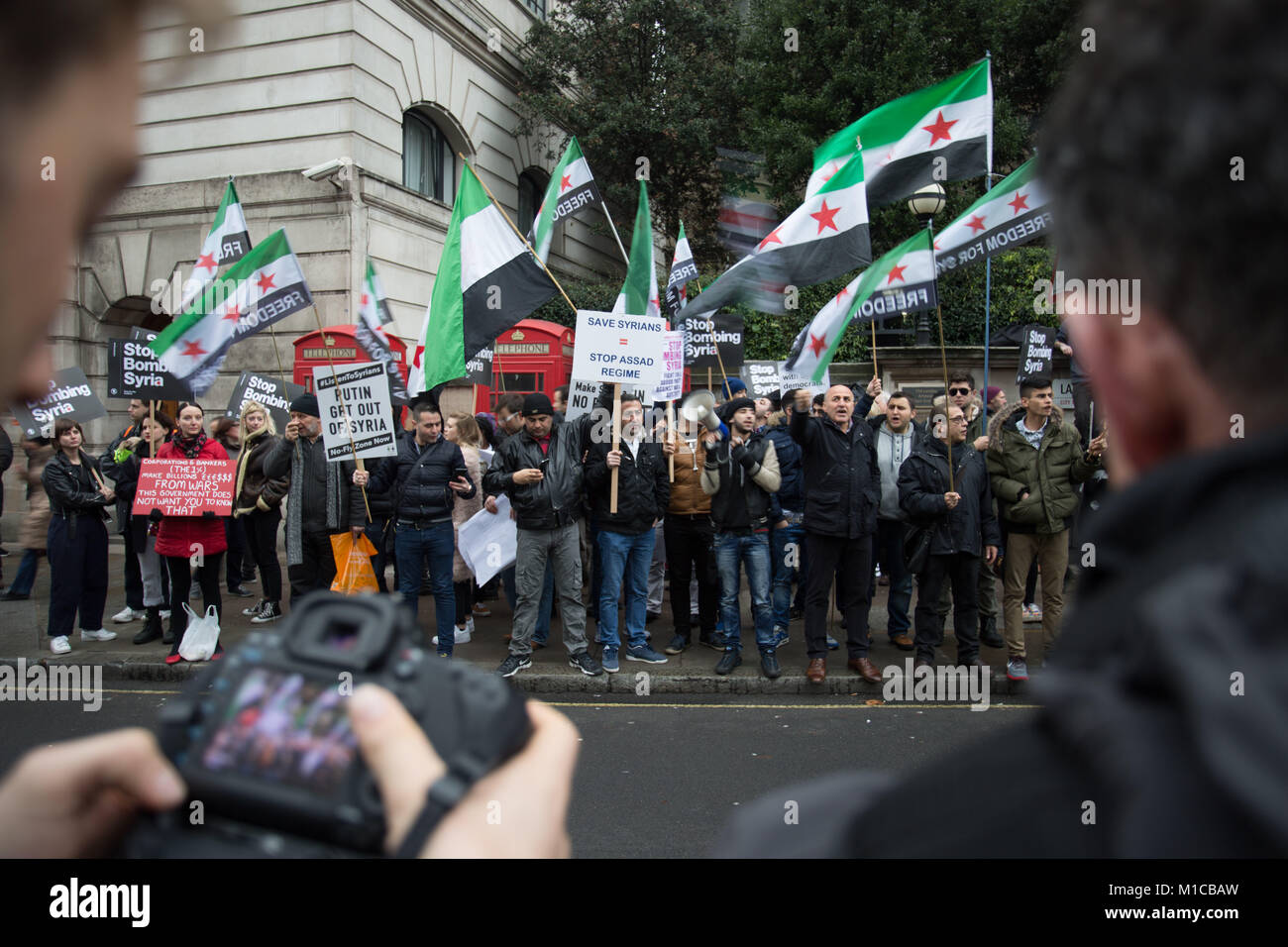 Dezember 12, 2015 - London, Vereinigtes Königreich - Demonstranten gesehen Anzeige der Freien Syrischen Armee Flagge während der Demonstration.. Tausende von Demonstranten gegen den Krieg protestieren außerhalb der Downing Street im Widerspruch zu den möglichen britische Beteiligung an der Bombardierung von Syrien. (Bild: © Rahman Hassani/SOPA über ZUMA Draht) Stockfoto