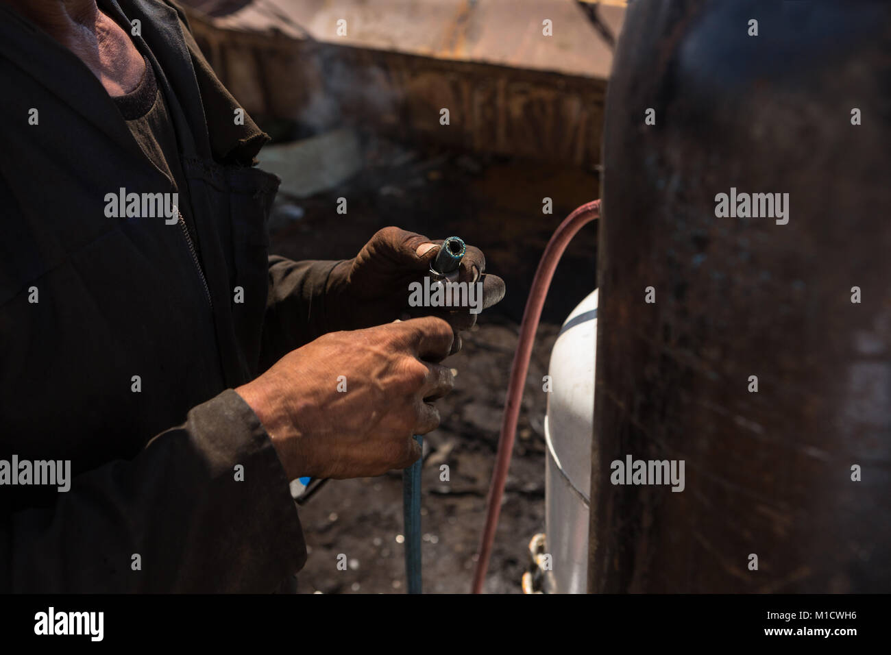 Arbeitnehmer mit einer Rohrleitung in der Nähe der Zylinder Stockfoto
