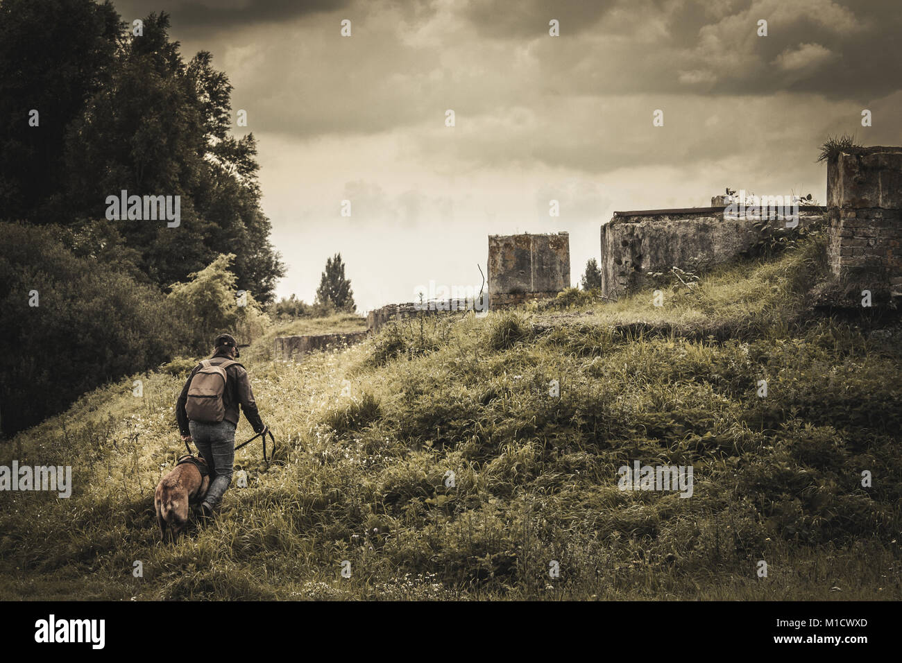 Frau und ihr Hund auf der Suche nach Häuser. die Entdeckung von verlassenen Gebäuden. post-Apokalypse. Stockfoto