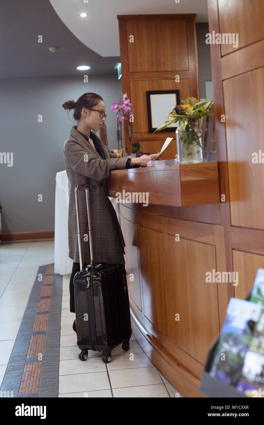 Frau liest Dokument an der Rezeption Stockfoto