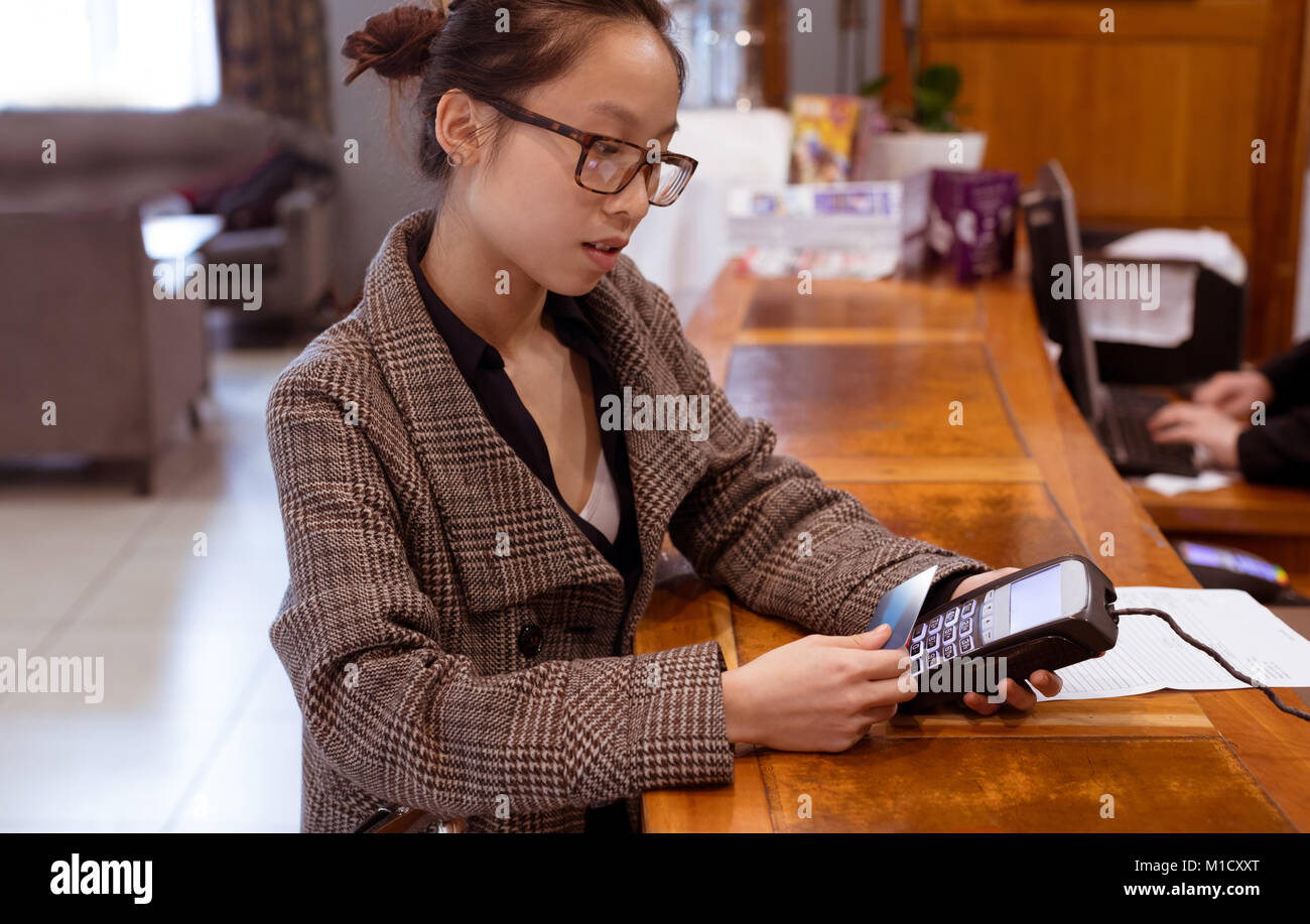 Frau streichen seine Karte auf Payment Terminal Machine Stockfoto