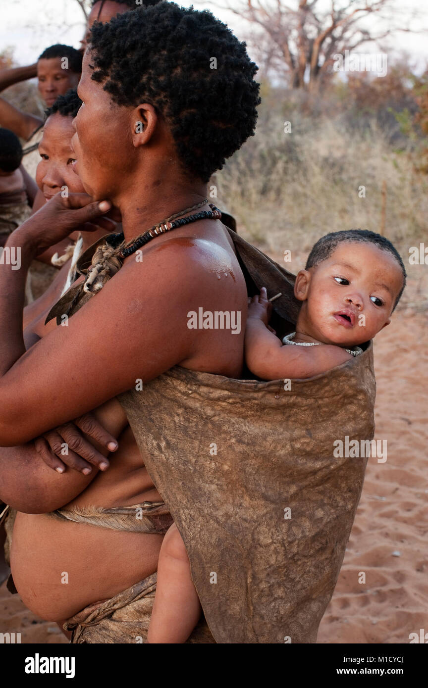 Ju/'Hoansi San Buschmännern Frau mit Baby. Sie sind Mitglieder der verschiedenen indigenen Jäger und Sammler Menschen im südlichen Afrika, Grashoek, Namibia Stockfoto