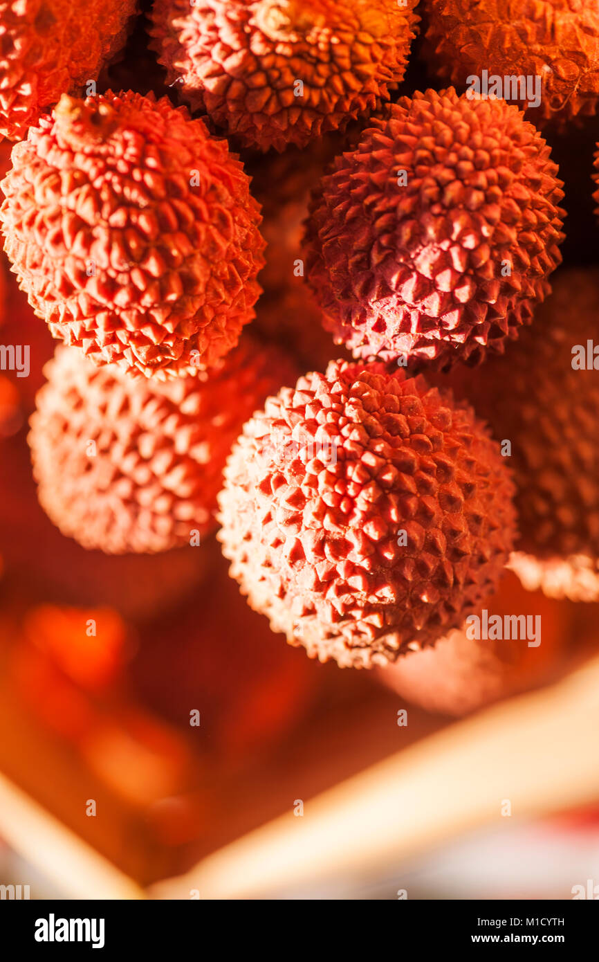 Litschi Früchte in einem Korb im späten Sonnenlicht. Stockfoto