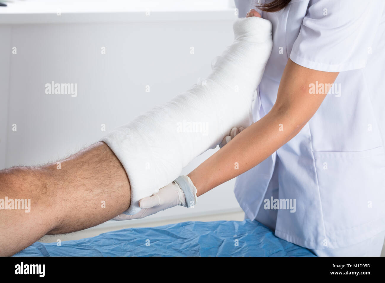 Nahaufnahme von einer Ärztin Untersuchen verletzte Person's Bein in der Klinik Stockfoto