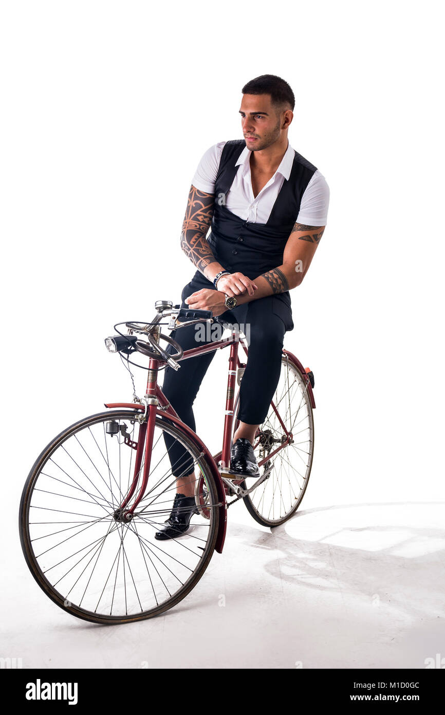 Porträt des jungen tätowierte Mann in eleganten Kleidern und Schuhen mit dem Fahrrad. Studio gedreht. Ganzkörperfoto Stockfoto