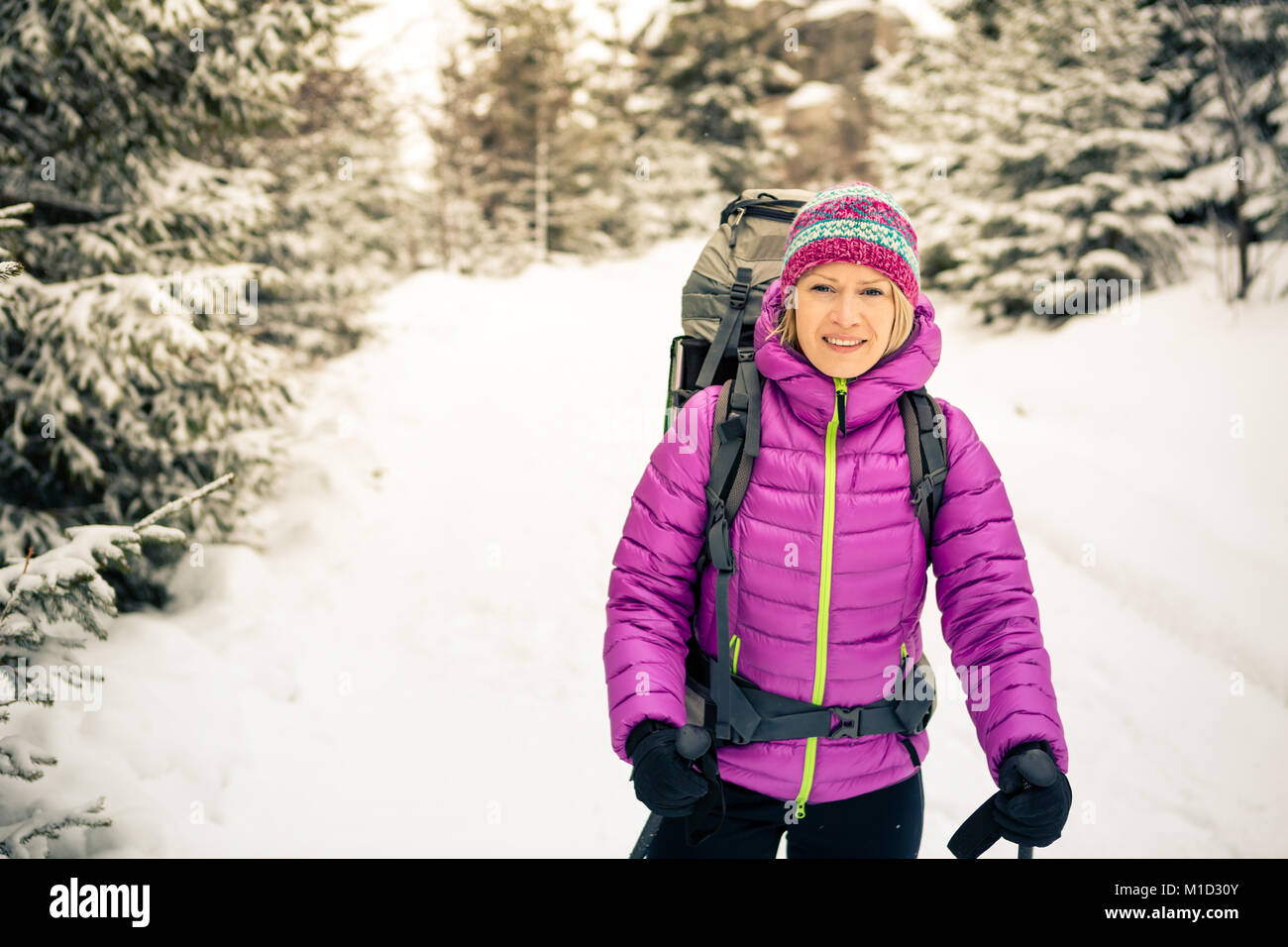Frau wandern in weiss Winter Forest Woods mit Rucksack. Erholung Fitness und gesunde Lebensweise draußen in der Natur, Camping im Freien. Motivation und Stockfoto