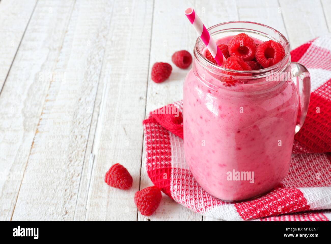 Gesunde himbeer Smoothie in einem Marmeladenglas Glas, Tisch Szene, seitliche Ausrichtung, gegen weiße Holz Stockfoto