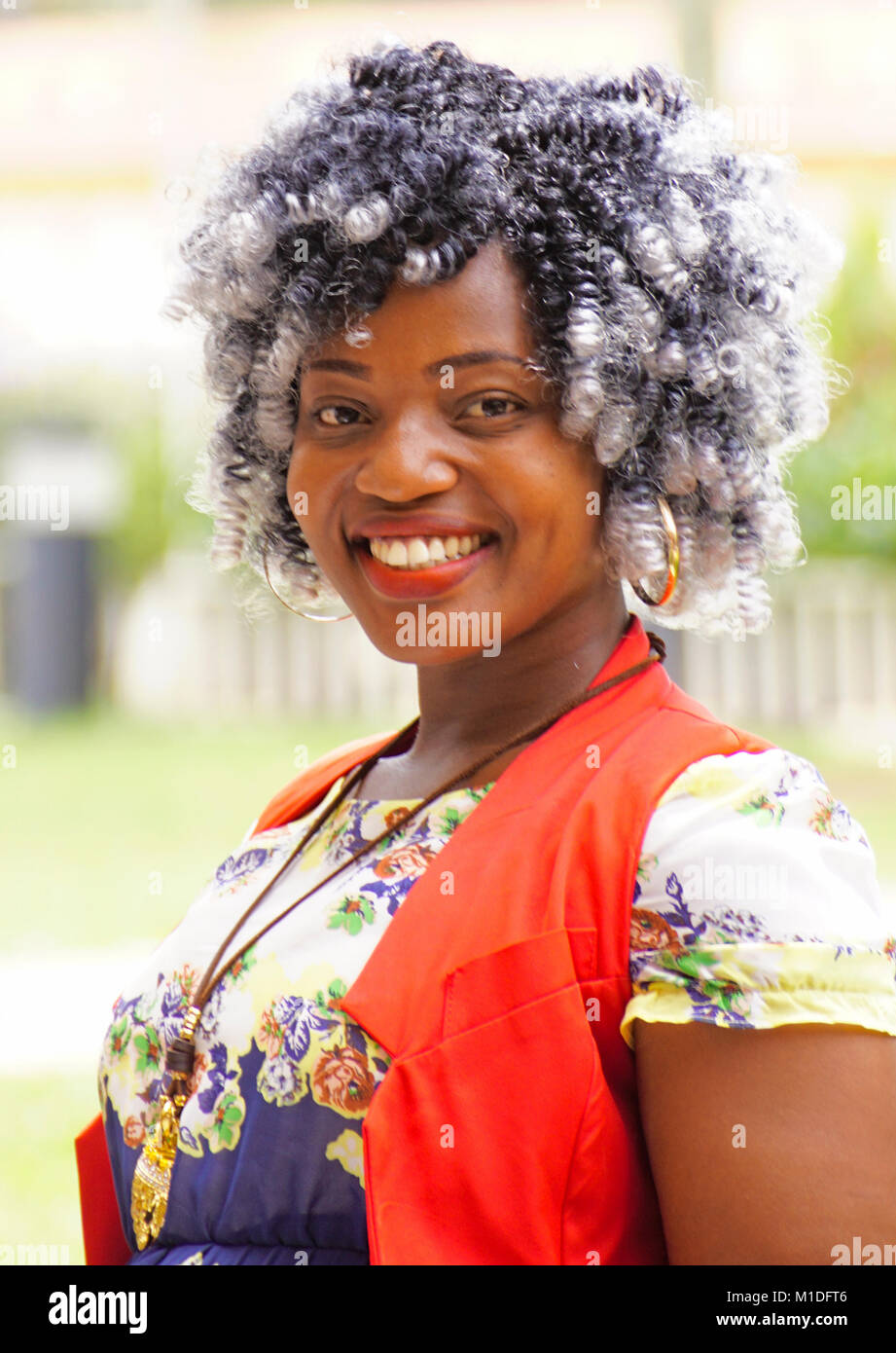 Portrait von modischen jungen Kampala Frau mit eleganten schwarzen und weißen Locken. Stockfoto