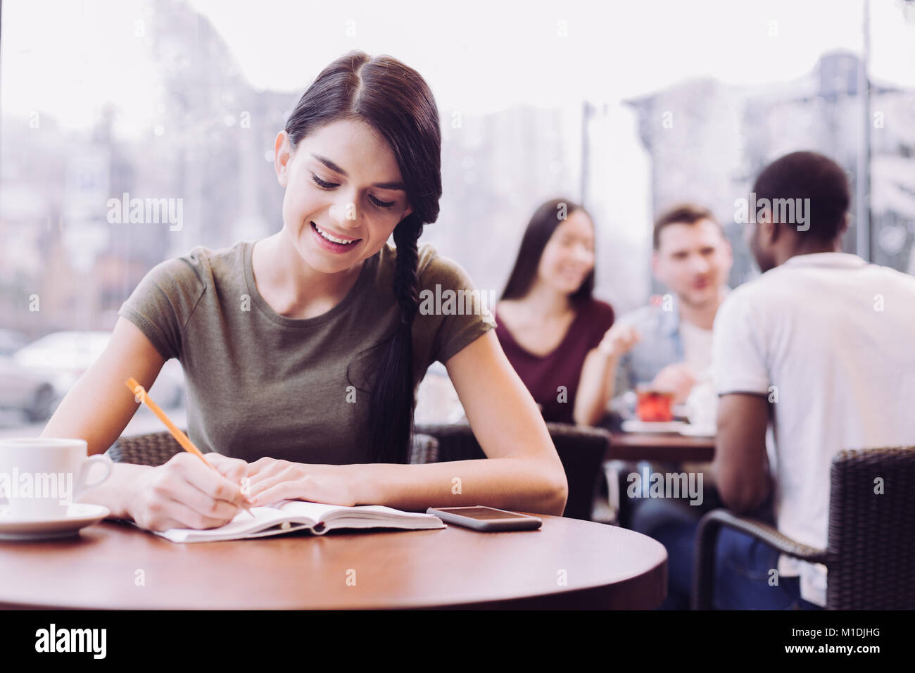 Begeisterte Schülerin schreiben Hausaufgaben Stockfoto