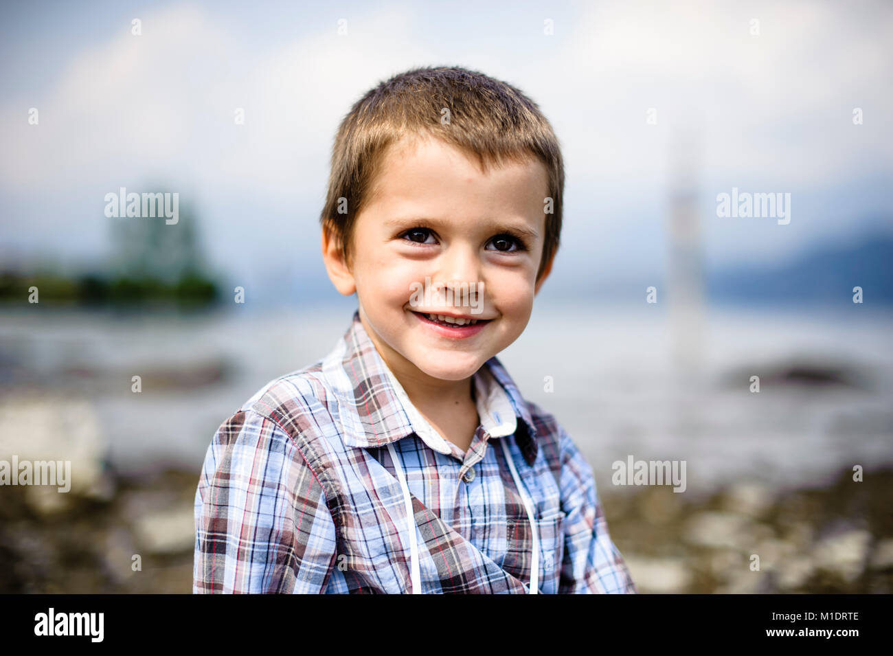 Portrait von 4 Jahre alten Jungen lächelnd in außen am Ufer des Sees Stockfoto