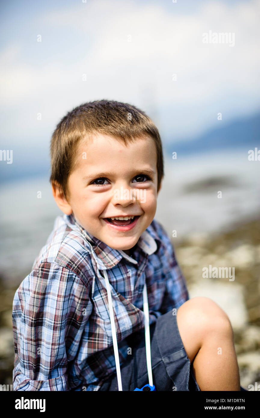 Portrait von 4 Jahre alten Jungen lächelnd in außen am Ufer des Sees Stockfoto