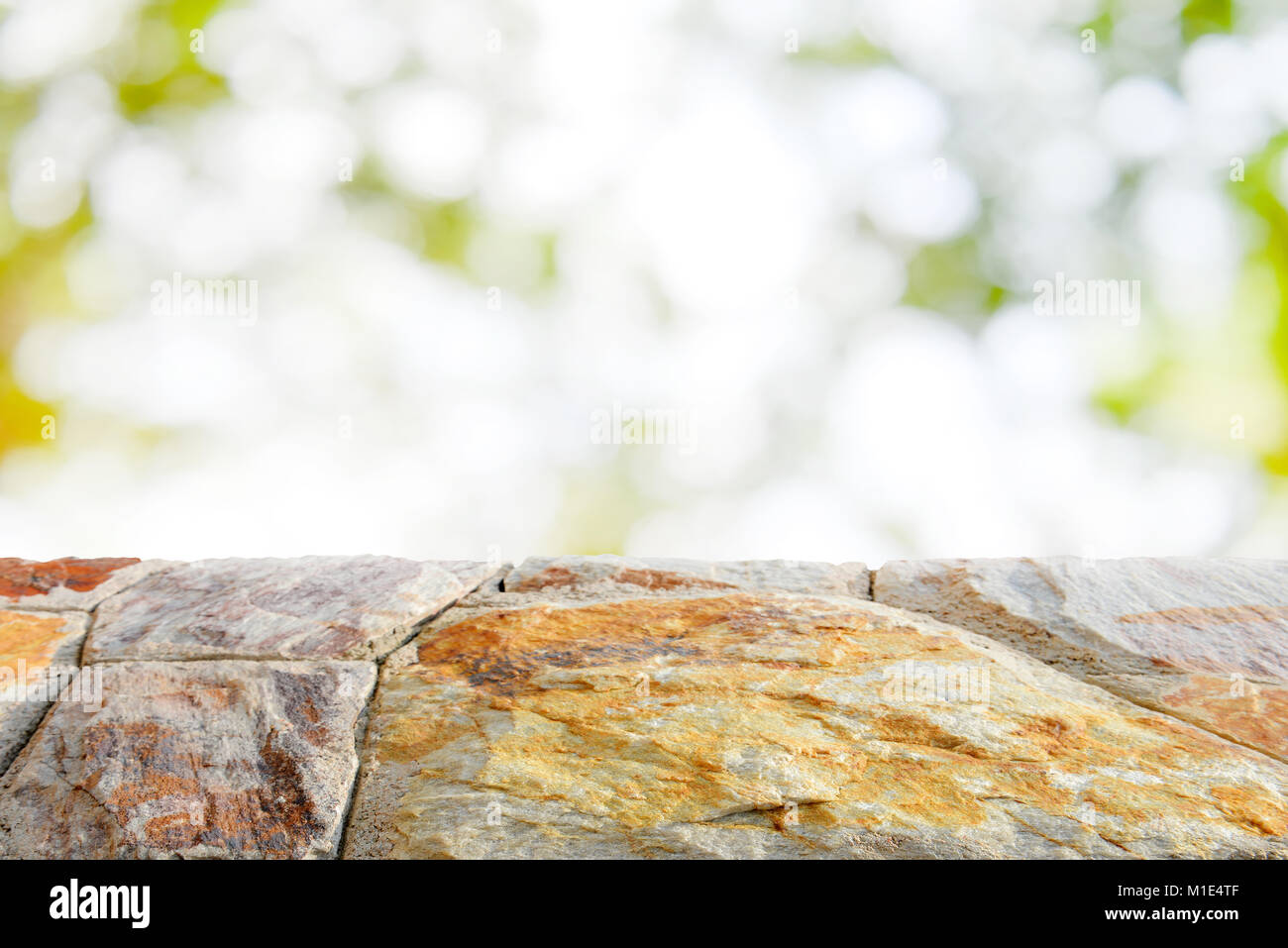 Braun Stein Tischplatte auf Verschwommene grüne Blätter abstrakt Hintergrund - verwendet für ihre Produkte Display bokeh Stockfoto