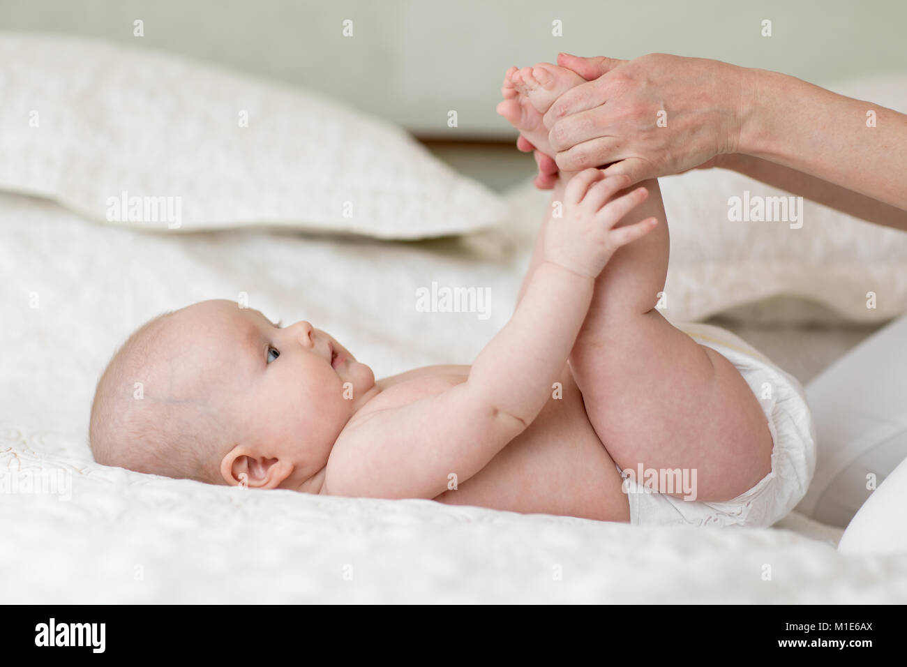 Mutter oder masseuer massieren Baby Mädchen im Zimmer Stockfoto