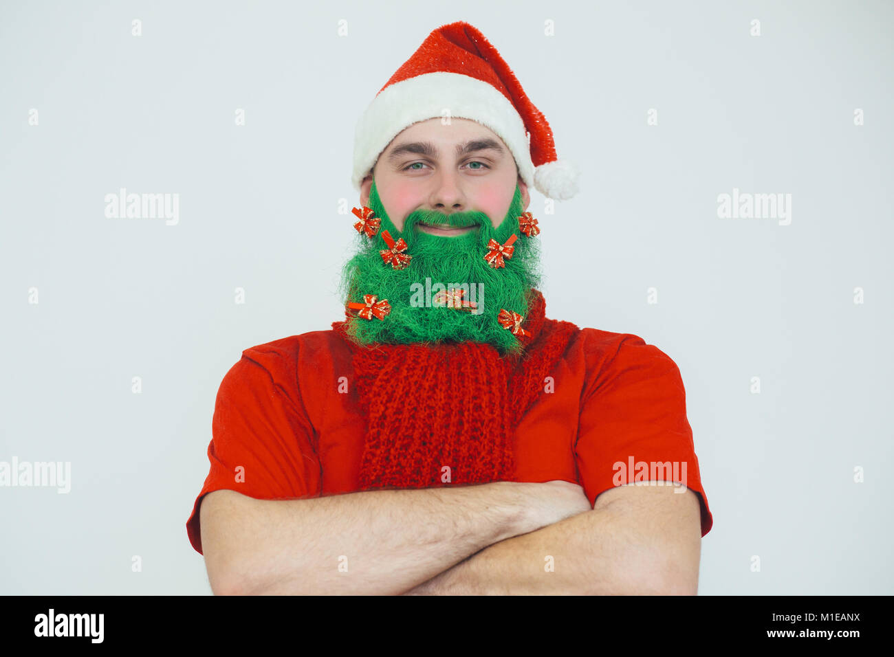 Santa Clause in roter Kleidung mit grünem Bart mit roten Bogen wie ein Weihnachtsbaum dekoriert Stockfoto