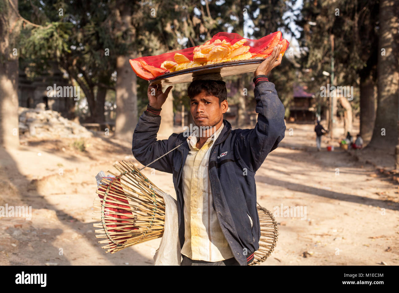 Ein Hausierer trägt Früchte auf seinem Kopf in Pashupati Area in Kathmandu zu verkaufen. Stockfoto