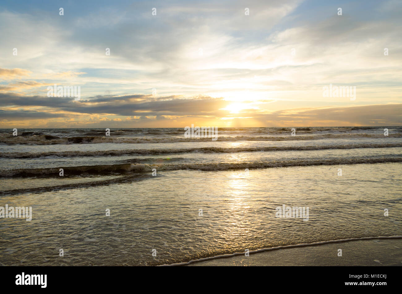 Blick auf den Sonnenaufgang am Strand mit der Reflexion der Sonne im Wasser. Stockfoto