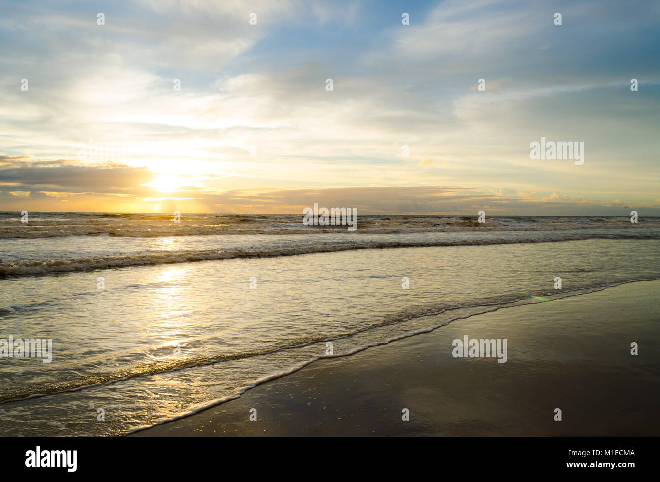 Blick auf den Sonnenaufgang am Strand mit der Reflexion der Sonne im Wasser. Stockfoto