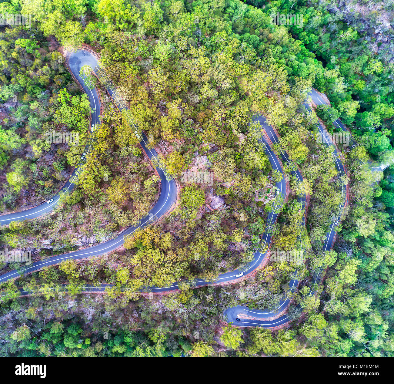 Häufige scharfe Kurven auf einer abgelegenen Straße steilen Hügeln Seite des Gum-Baum Creek im Nationalpark von Australien abgedeckt. Luftaufnahme von Pass Stockfoto