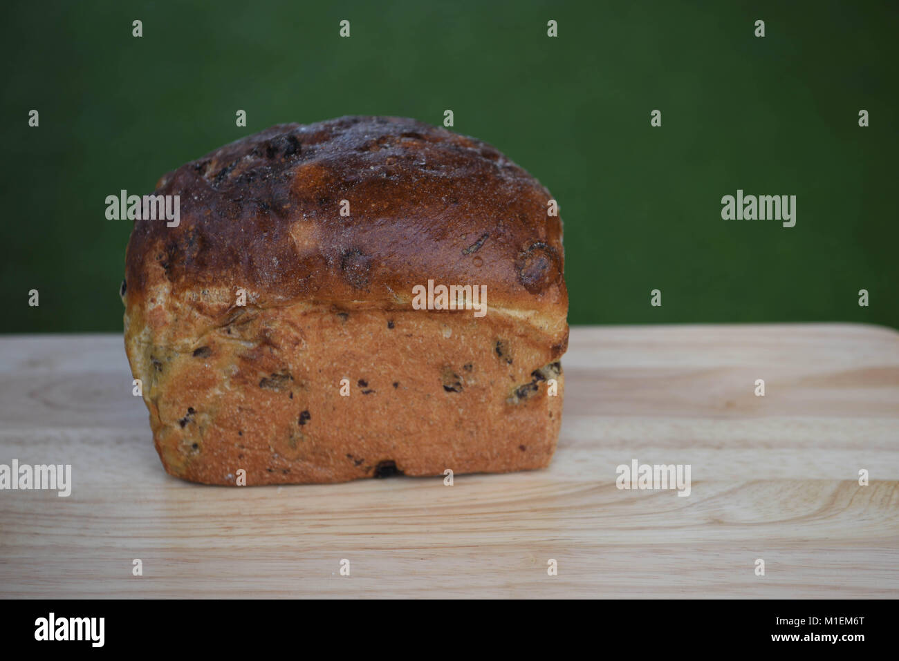 Nahrung Der fruchtig frische, hausgemachte gebackene Brot auf einem Holz Schneidebrett und im Freien grüne Gras Hintergrund für Sommer Stockfoto