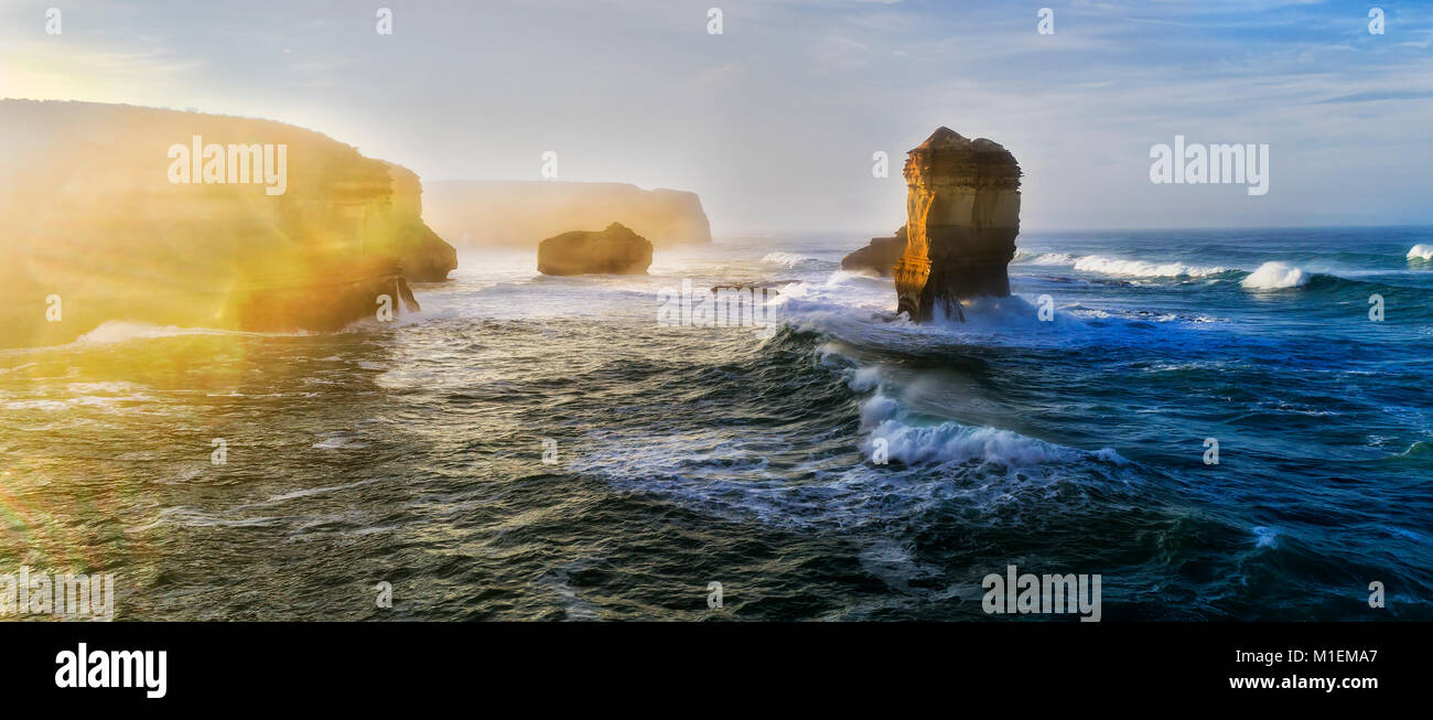 Mächtige Kampf zwischen Meer, Land und Licht bei Sonnenaufgang um zwölf Apostel Felsformation im Marina Park an der Great Ocean Drive, Australien. Stockfoto