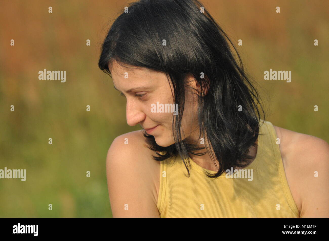 Die Frau unterhalten und nachdenklich. Mädchen mit Ohrringe. Lächeln und Zufriedenheit. Stockfoto
