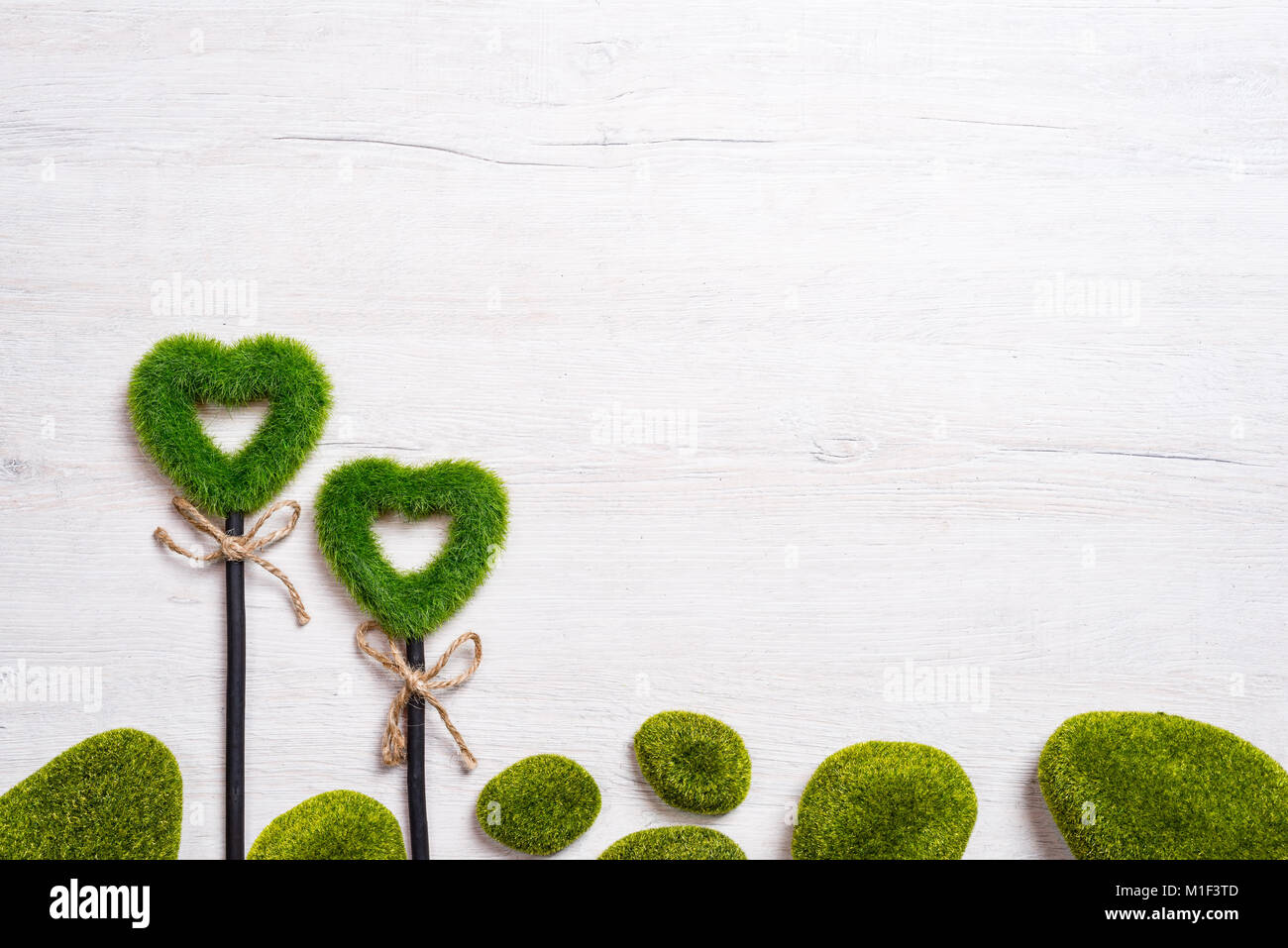 Zwei grüne Wiese Herzen auf einem weißen Holz- Hintergrund. Das Konzept der Valentinstag Stockfoto