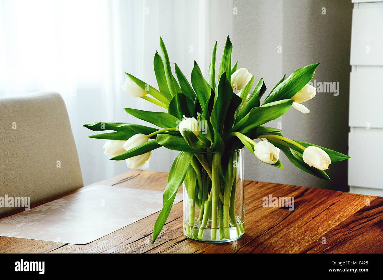 Bündel weißen Tulpen in einer transparenten Glas Vase auf hölzernen Tisch  Stockfotografie - Alamy