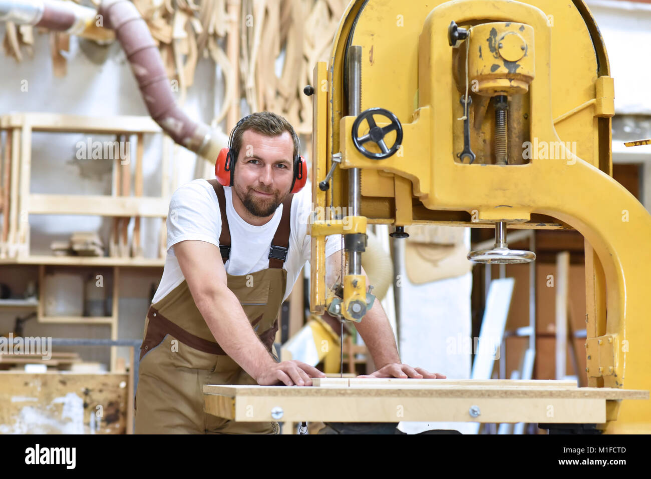Porträt eines Zimmermanns in Arbeitskleidung und Gehörschutz in der Werkstatt der Schreinerei Stockfoto