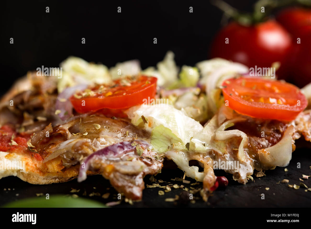 In der Nähe von Slace von kebap Pizza mit getrockneten Oregano auf dunklem Schiefer Stockfoto