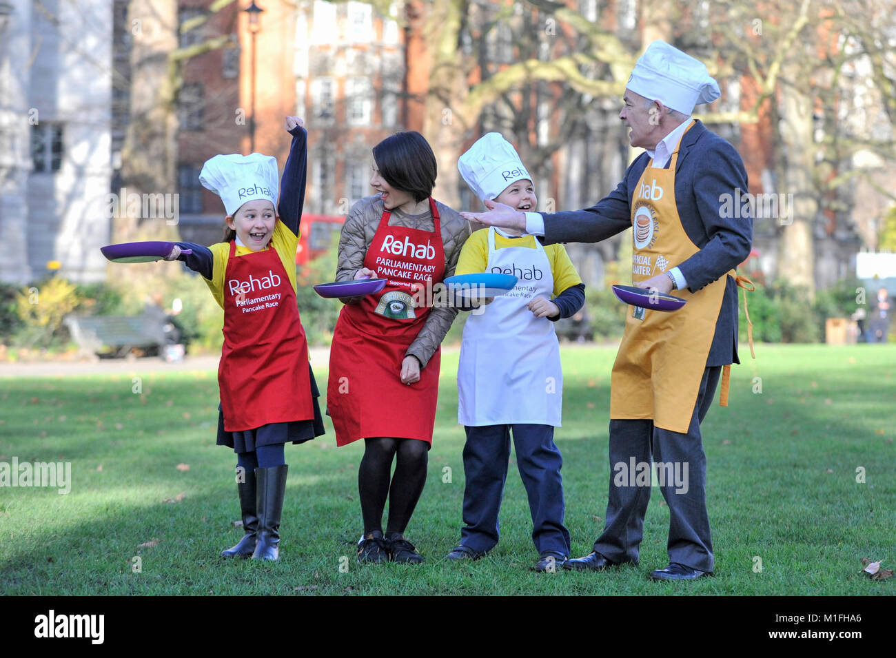 London, Großbritannien. 30 Jan, 2018. Race Veteran und der diesjährigen offiziellen Starter, ITV-Nachrichtensprecher, Alastair Stewart OBE, und ITV News' Lucrezia Millarini für die Media Team, ein Pfannkuchen rennen Bootcamp in Westminster vor dem Main Event, das Rehab parlamentarischen Pancake Race, am Faschingsdienstag. Sie werden vom Team Maskottchen Gnade und Jakob, beide 8 Jahre alt, von der St. Matthew's Primary School in Westminster. Credit: Stephen Chung/Alamy leben Nachrichten Stockfoto