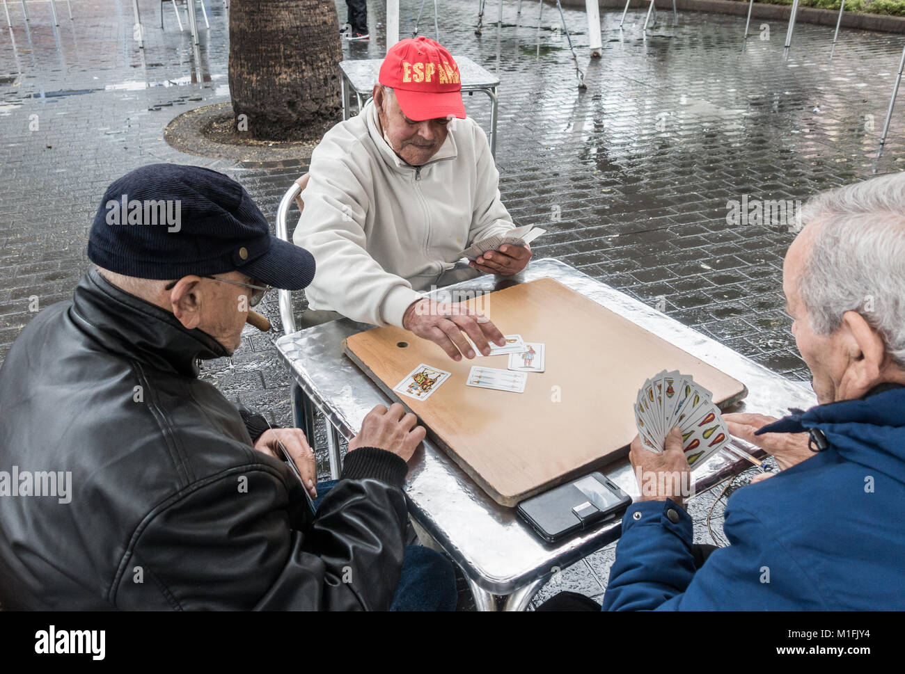 Las Palmas, Gran Canaria, Kanarische Inseln, Spanien. 30. Januar, 2018. Wetter: Einheimische, die Karten im Regen auf einer nassen und kalten Dienstag Morgen in Las Palmas, der Hauptstadt Gran Canarias. Ein ungewöhnlich kalten Bann von Wetter für die Kanarischen Inseln als langsame niedriger Druck bringt Regen, Schneeregen und Schnee auf den Inseln. Credit: ALAN DAWSON/Alamy leben Nachrichten Stockfoto