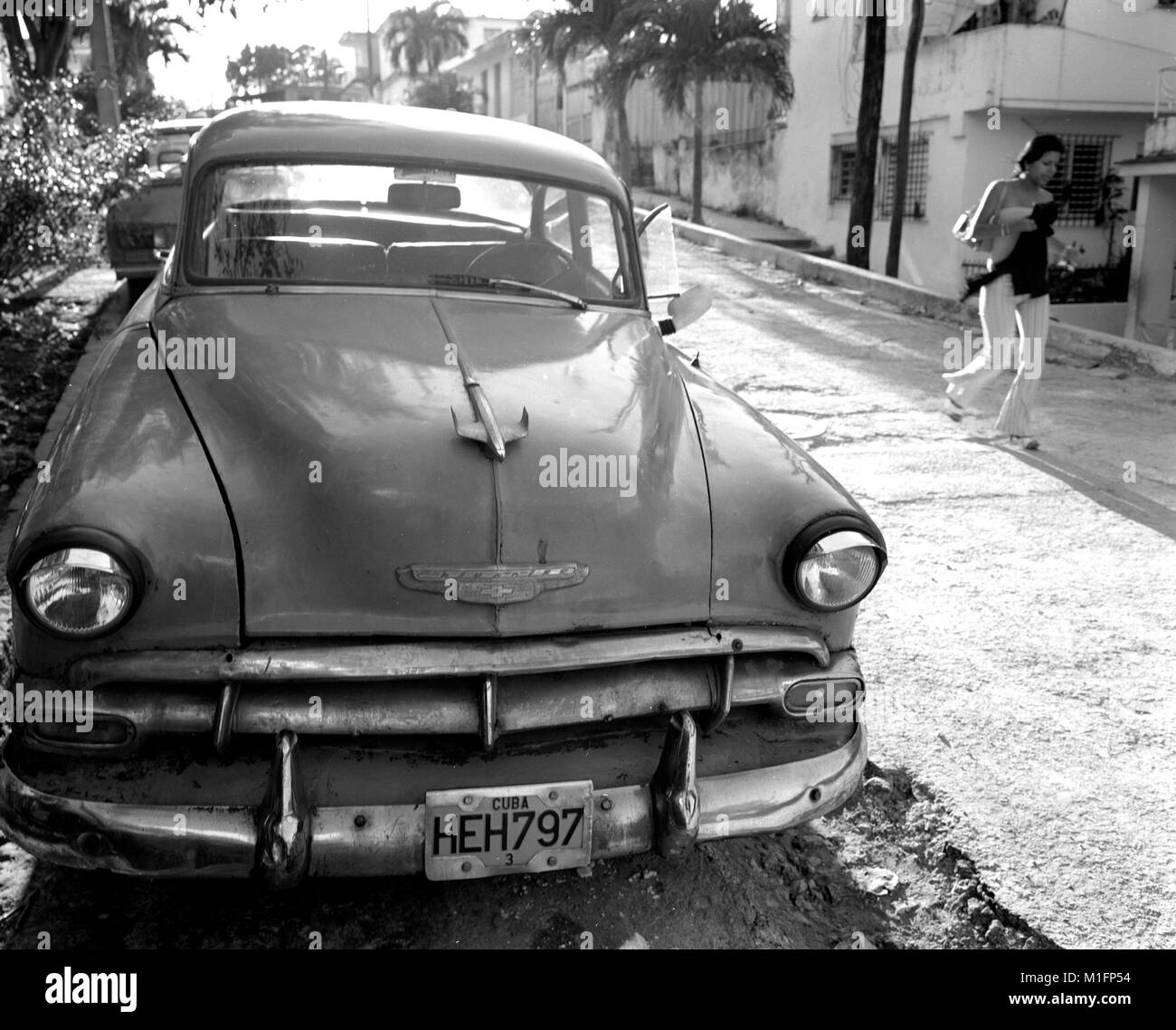 Havanna, Kuba. 15. Februar 2006. Kubanischen Mädchen geht vorbei an einer der vielen kubanischen locken, aka Yank Tanks oder vor 1960 American Classic Autos in den Straßen von Havanna. Am 31. Juli 2006 übertragen Castro, nach einer Darm-Operation, seine Verantwortung gegenüber der Vize-Präsident, seinen jüngeren Bruder Raœl. Castros Nichterscheinen an seinem 80. Geburtstagsfeier angeheizt berichtet, dass er terminal Magenkrebs hat. Kubanische Beamte erklärte, dass Castro keine unheilbare Krankheit hat und schließlich in seinen öffentlichen Pflichten kehrt. Kuba ist in einer 50er Jahre Zeitkapsel balanciert, um für immer zu verändern. Stockfoto