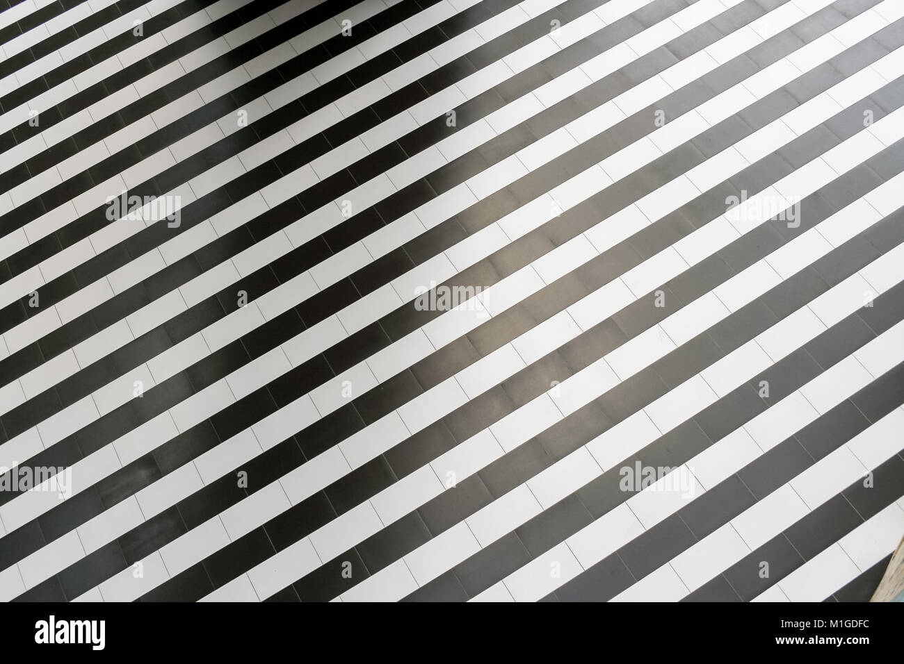 Abstrakte geometrische Muster der regelmäßigen abwechselnd schwarze und weiße Streifen auf dem Boden. Stockfoto