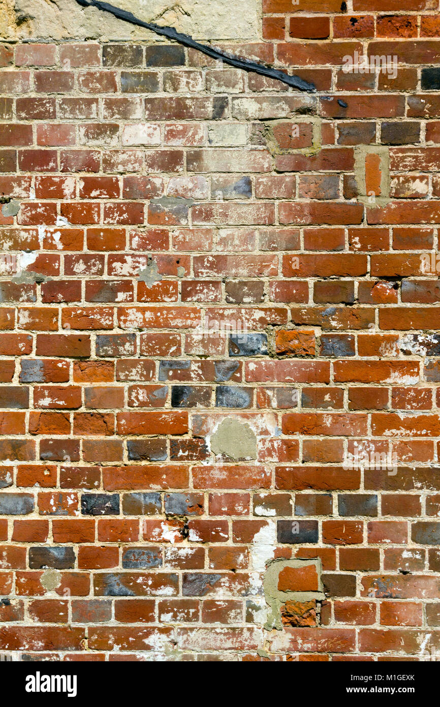 Alte schwer beschädigte und schlecht repariert Red brick wall Close up full frame Stockfoto