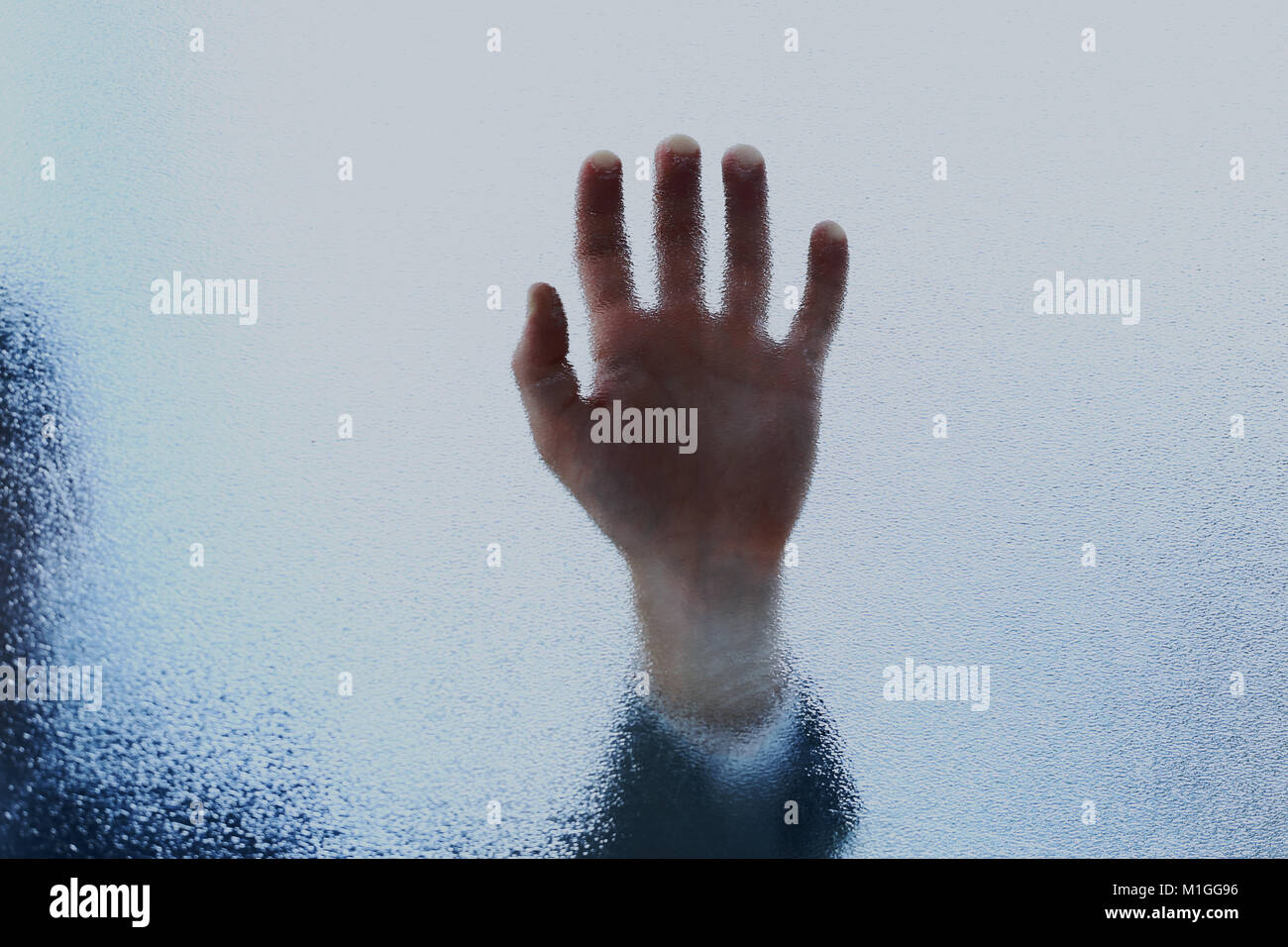 Eine Handvoll lehnte sich auf sandgestrahlte Glasplatte. Stockfoto