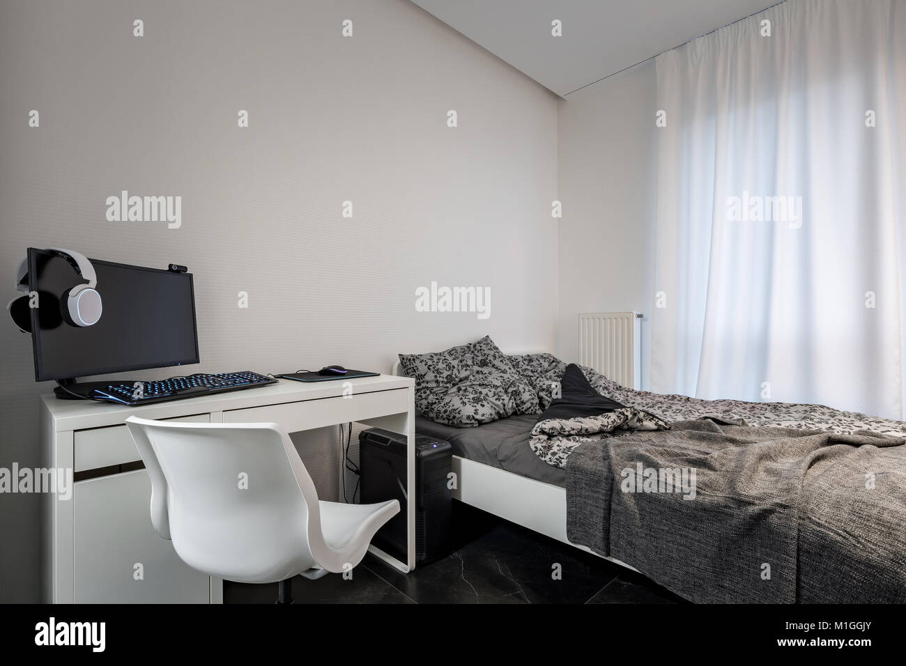 Schlafzimmer mit Einzelbett, weiß Schreibtisch und Stuhl Stockfoto