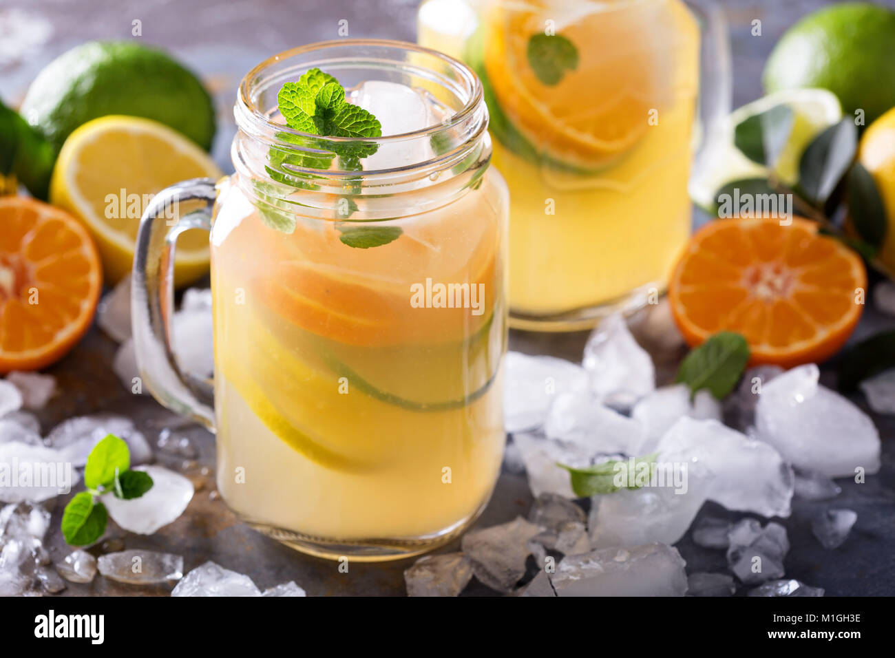 Citrus Limonade mit Scheiben von Orangen, Zitronen und Limetten in Maurergläser Stockfoto