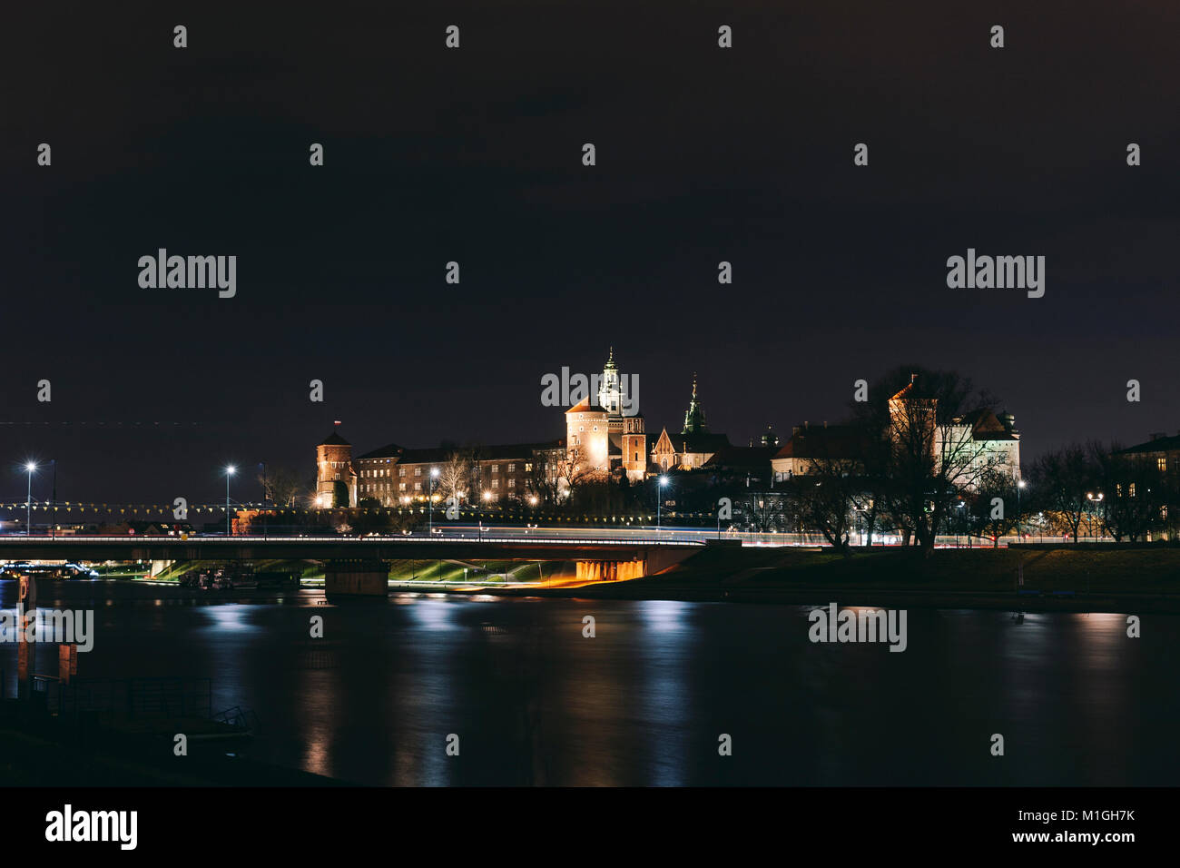 Schloss Wawel in Krakau, Polen mit Grunwaldzki Brücke in die Weichsel in der Nacht wider Stockfoto