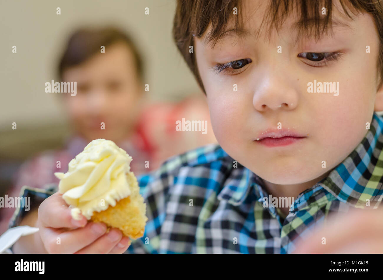 Eine Nahaufnahme eines Jungen essen eine Cupcake. Stockfoto
