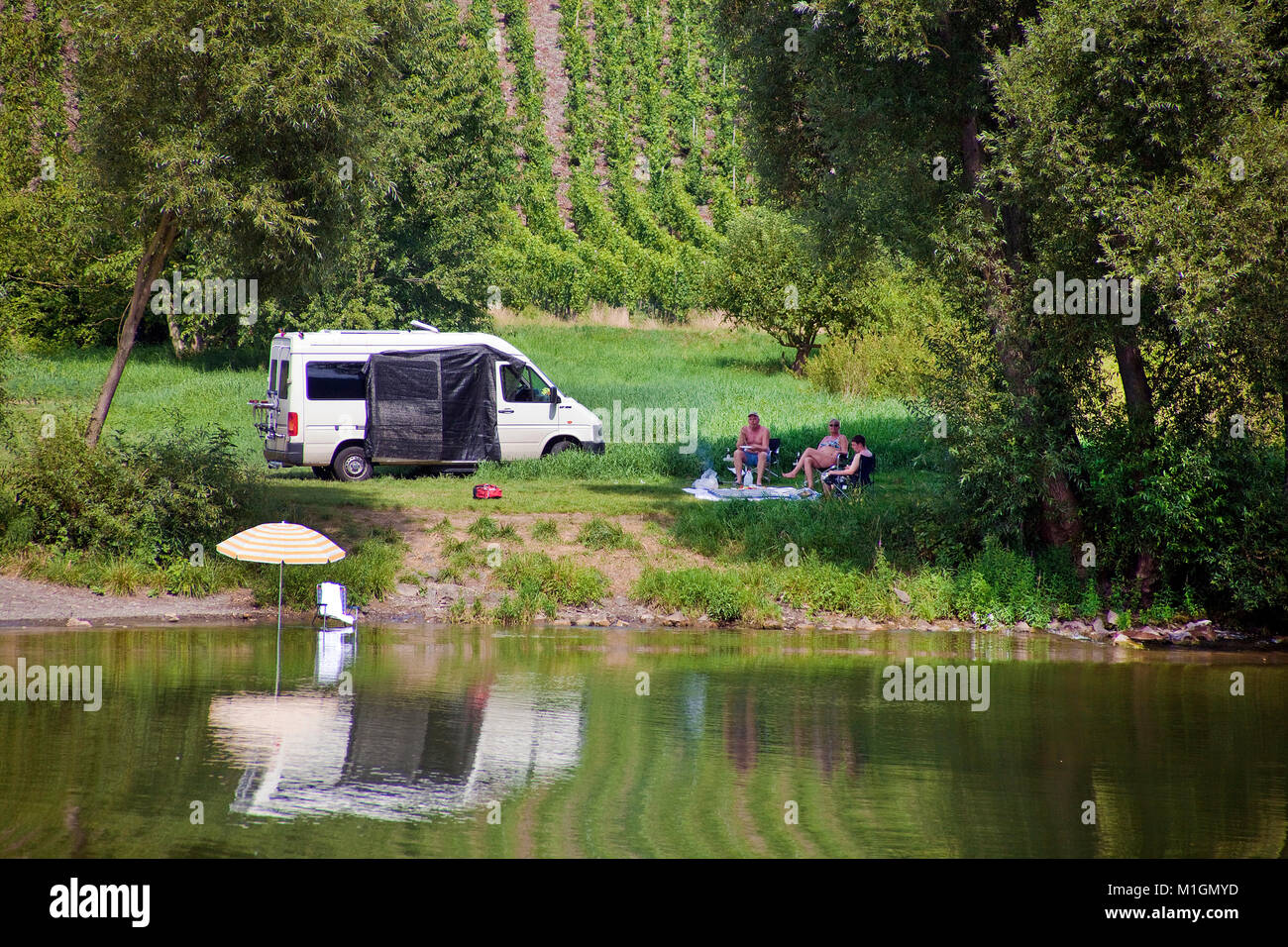 Wildes Campen am Flußufer, Menschen im Schatten eines Baumes sitzend, Mosel bei Traben-Trarbach, Mosel, Rheinland-Pfalz, Deutschland, Europa Stockfoto