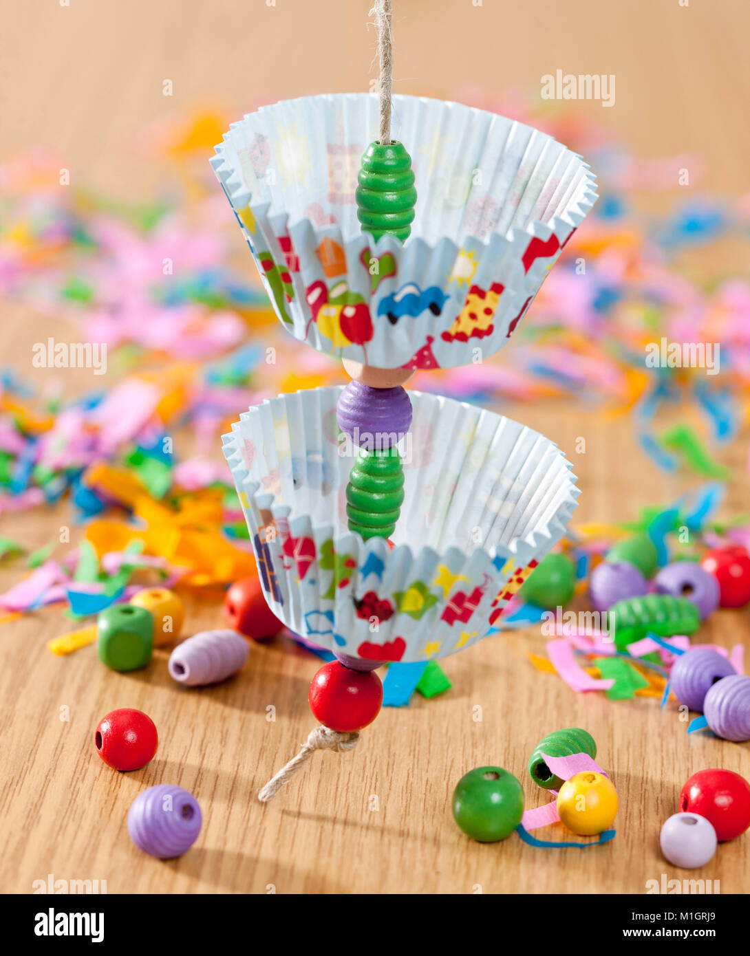 Wellensittich, Wellensittich (Melopsittacus undulatus). Einbauanleitung für budgeriar Spielzeug, aus Papier muffin Büchsen und Holzperlen. Deutsche Stockfoto