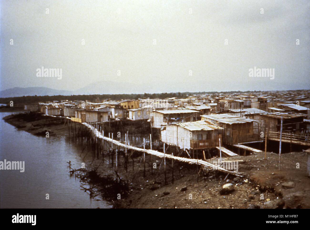 Landschaft Foto einer informellen Siedlung von Cholera betroffenen, zahlreiche Häuser auf Stelzen neben einem Körper von Wasser, Ecuador, 1992. Mit freundlicher CDC. () Stockfoto