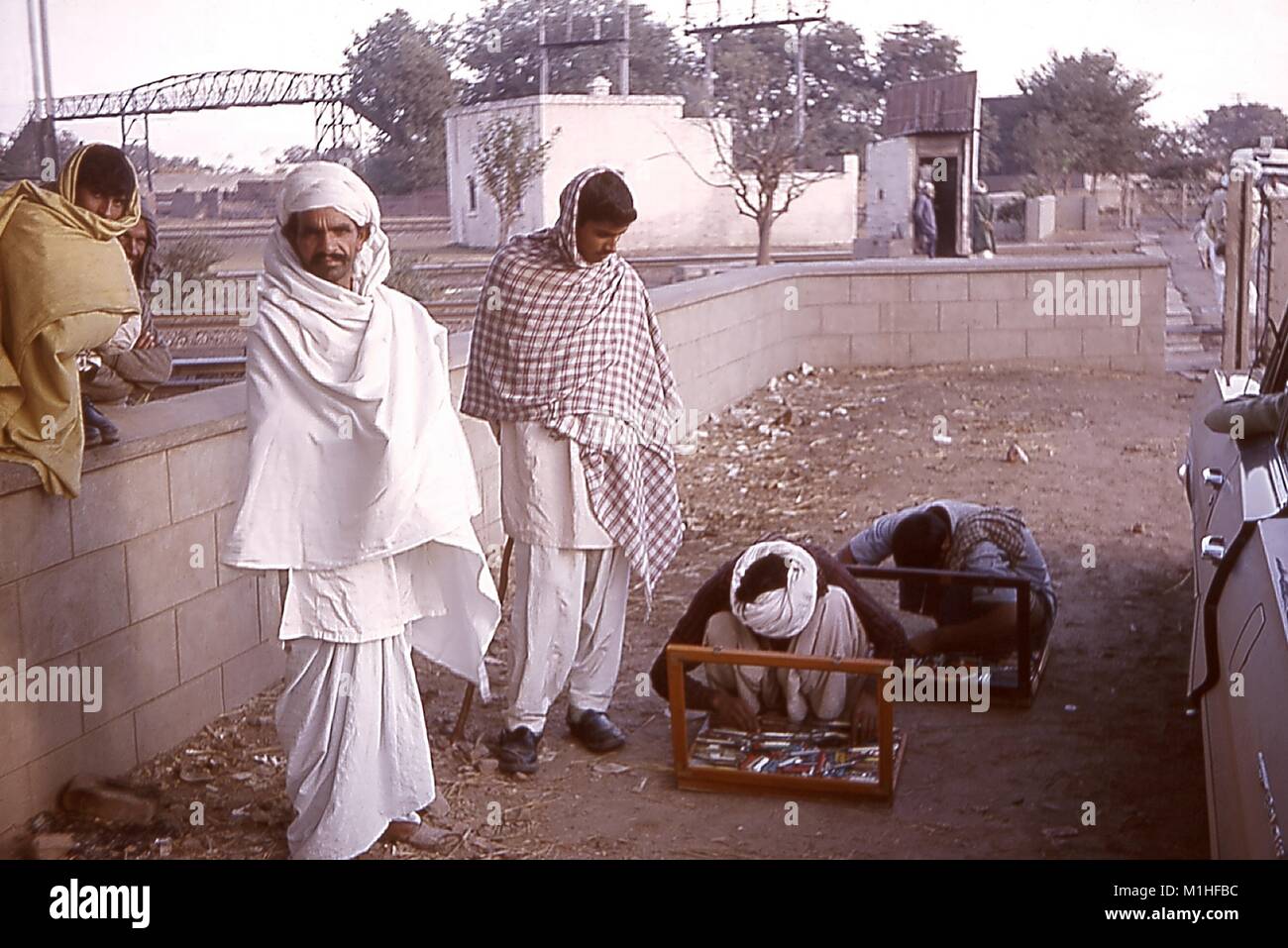Foto von Hausierer, die traditionelle Schals, Messer verkaufen auf einer Straße, Gujranwalla, West Pakistan (Pakistan), 1964, 1964. Mit freundlicher CDC. () Stockfoto